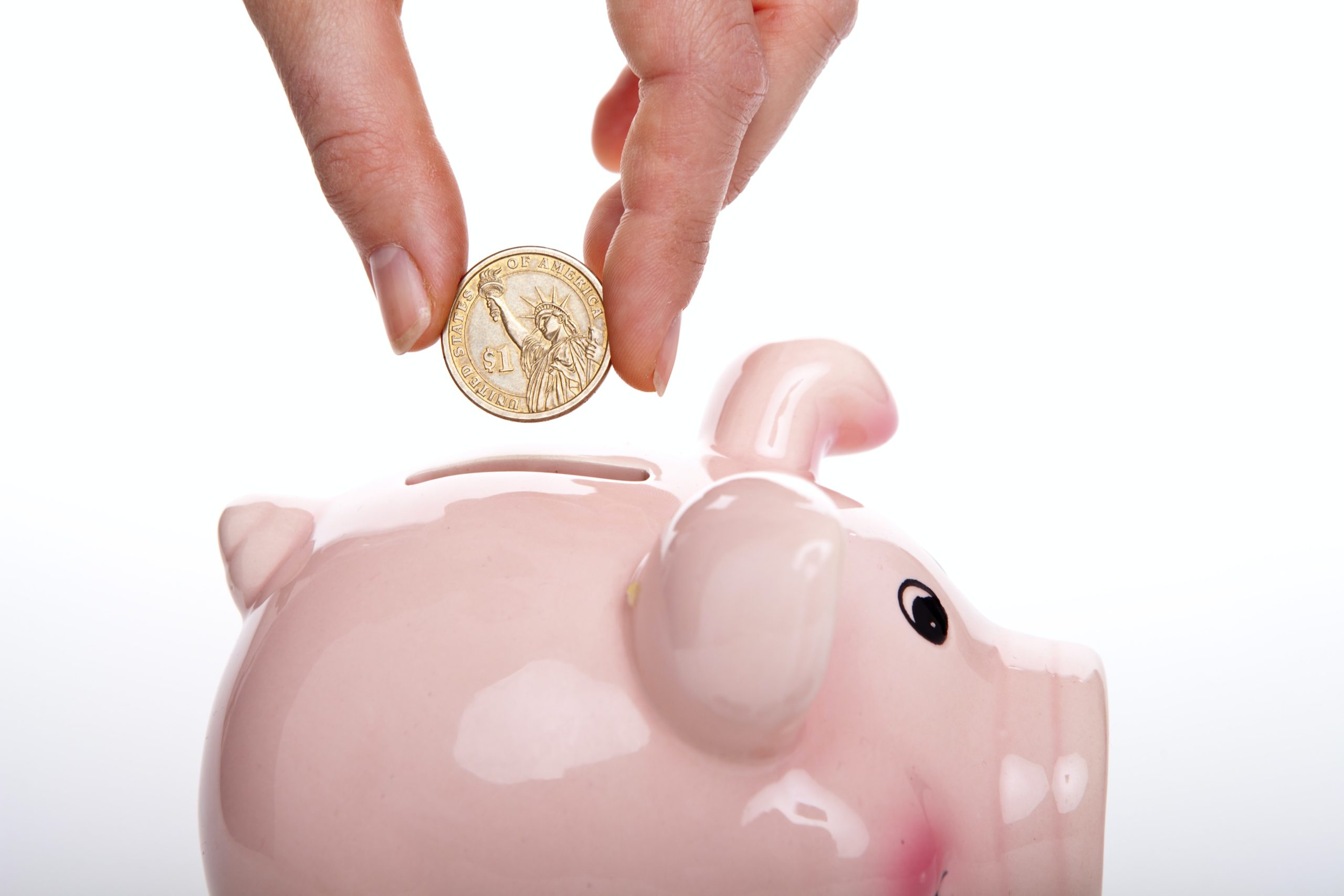 putting a coin into a piggy bank